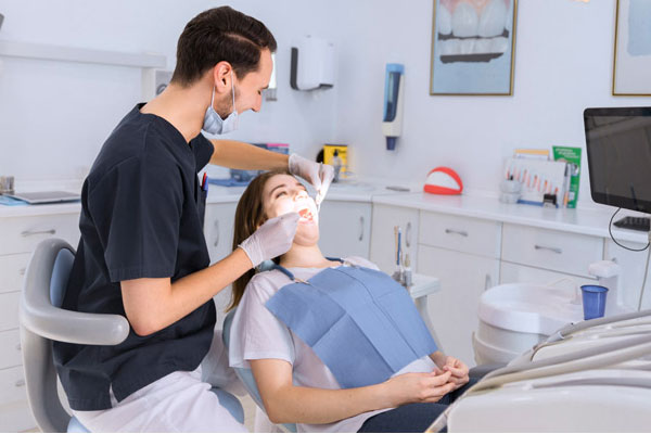Dentist performing a dental procedure on a patient at Elite Dental Touch