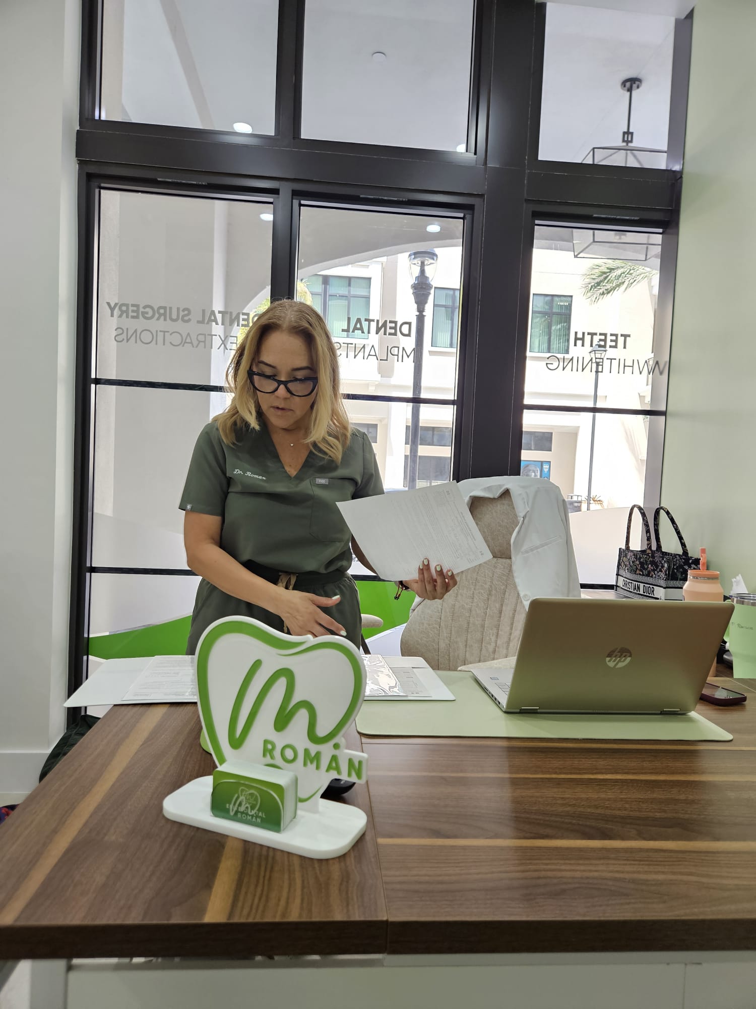 Dr. Maria Roman reviewing patient documents at Elite Dental Touch office