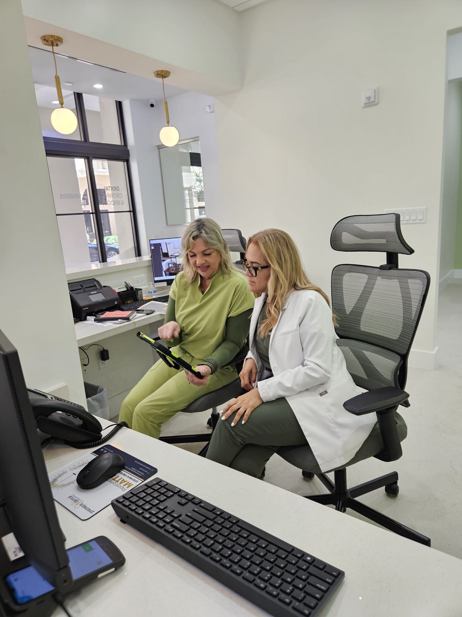 Elite Dental Touch staff reviewing patient records at the front desk