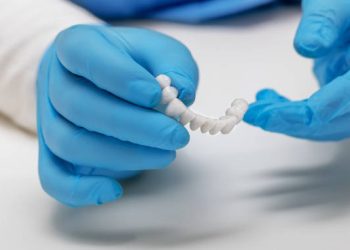 Dental Bridge 5 dentist holds ceramic dental crowns in his hands, zirconium bridge, close-up. High quality photo