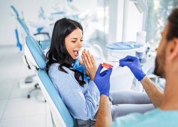 Dental Implants 4 Male Dentist Explaining Procedure Using Artificial Jaw