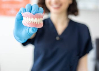 Dentist holding denture