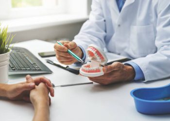 dentist and patient discussion about planned teeth treatment in dental clinic office