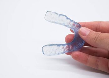 Nightguards / Mouthguards 8 Doctor holding a custom-made night guard designed for protecting teeth from grinding, showcasing essential dental health equipment