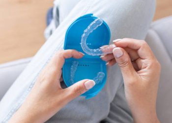 Nightguards / Mouthguards 2 personal perspective of woman's hands opening blue case and holding dental splint.dental appliance for correction of bruxism in the dentition when biting.oral care and dental treatment.