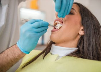 Tooth Bonding 6 A dentist is fixing the teeth of a female patient with the help of a dental nurse in the dental office