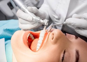 Teeth Cleaning 9 Dentist making professional teeth cleaning female young patient at the dental office. Close-up plan
